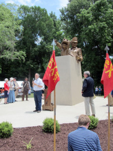 Sculptor Alex Palkovich in front of statue