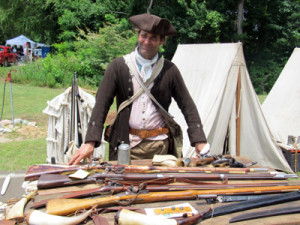 Revolutionary soldier with display of rifes